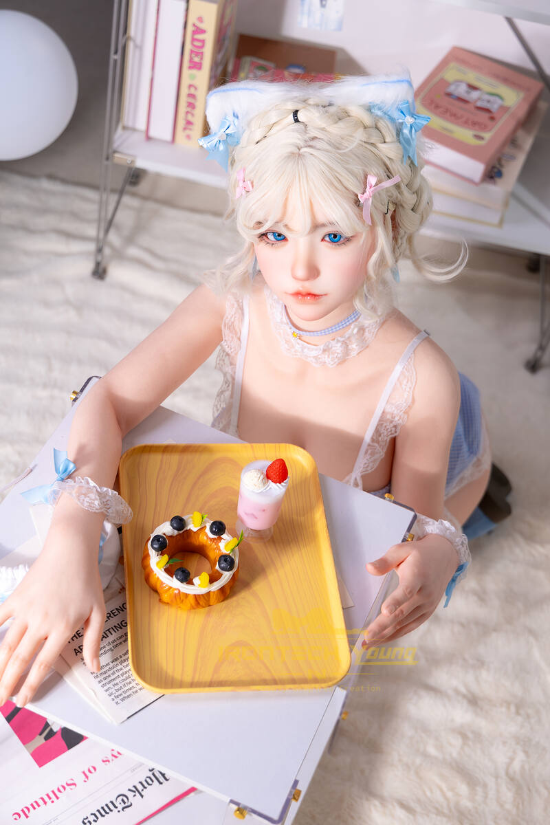 Dreamdoll Akiyama hält ein Tablett mit Süßigkeiten in einem hellen Zimmer